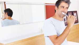 Mature man brushing his teeth to avoid cavities